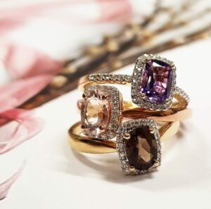 Image of three rings set in yellow gold with diamonds.